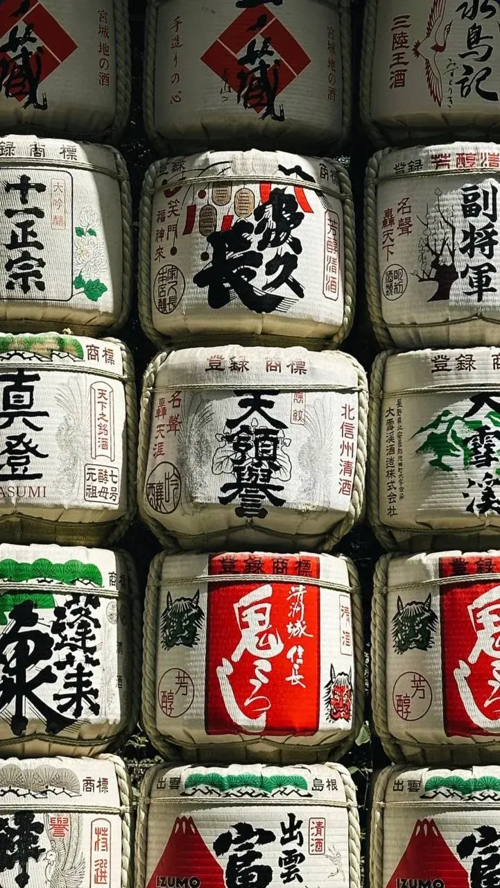 Stacked straw-wrapped sake barrels decorated with Japanese lettering